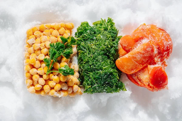 Briquetes coloridos congelados de bagas, verduras e legumes no gelo. vista superior. — Fotografia de Stock