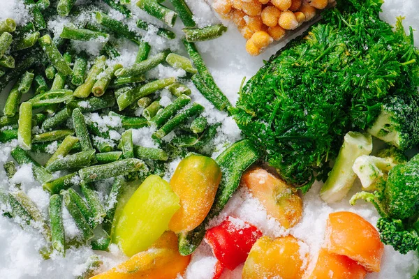 Tasty assortment of frozen berries, greens and veggies on grinded ice. top view. — Stock Photo, Image