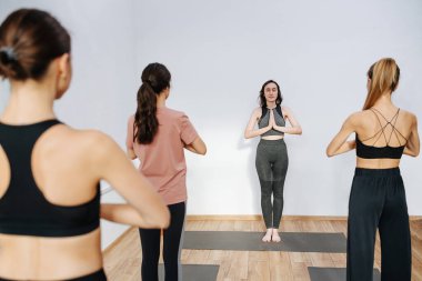 Meditasyon yapan kadınlar bir eğitmenin önünde yoga yaparlar, egzersiz yapmaya başlarlar.
