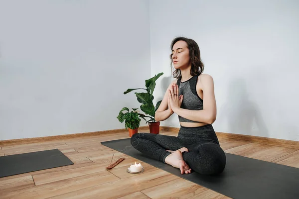 Spiriterad kvinnlig instruktör som utövar yoga, mediterar. Brännande rökelsekäpp Stockbild