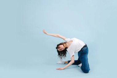 Dizlerinin üzerinde duran, vücudunu geriye doğru büken sanatsal çağdaş dansçı.