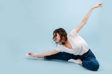 Modern çağdaş dansçı yarı kelebek modasında oturuyor.