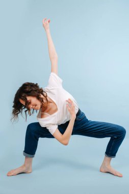 Dizleri dik açıda neşeli çağdaş dansçı. Vücudunu döndürüyor.