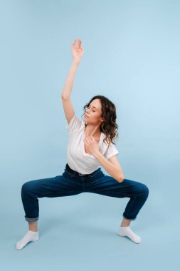 Kalçaları bir çizgide, dizleri dik, dalmış modern dansçı.