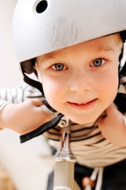 Bisikletli küçük sarışın bir çocuğun yakın portresi..