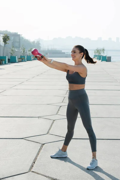 Gelukkige Brunette Oefenen Het Trottoir Buiten Met Kleine Kettlebell Zwaaien — Stockfoto