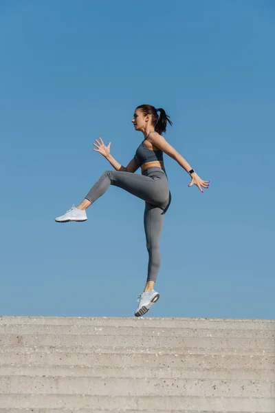 Atletische Brunette Die Buiten Traint Haar Knieën Gaat Achterwaarts Rent — Stockfoto