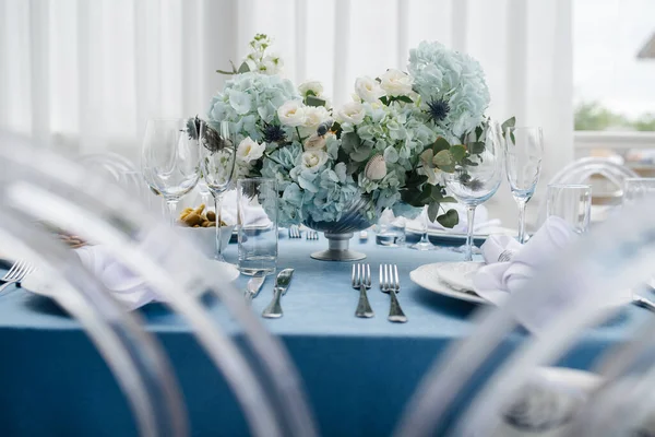 豪华的圆桌布置 装饰着郁郁葱葱的蓝色花朵 低角度 — 图库照片