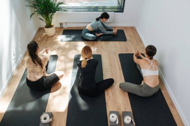 Yoga yapan, yerde uzanan bir grup insanın yüksek açılı görüntüsü.
