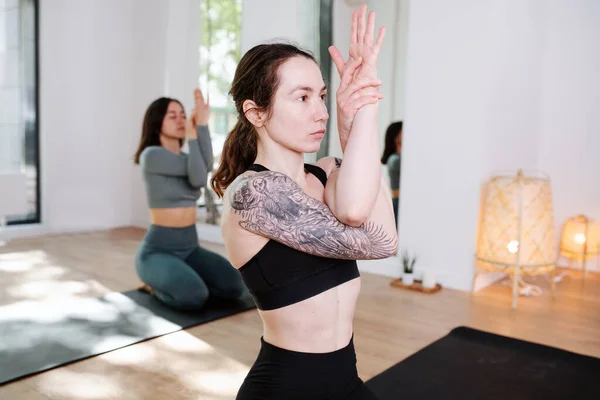 Femmes intégrées pratiquant le yoga en groupe, méditant avec les bras entrelacés — Photo