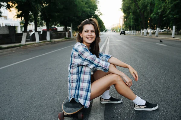 Mulher Sorridente Animada Sentada Skate Meio Uma Estrada Vazia Cidade — Fotografia de Stock