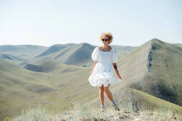 Giggly Donna Con Capelli Ricci Abito Bianco Che Soffia Nel — Foto Stock