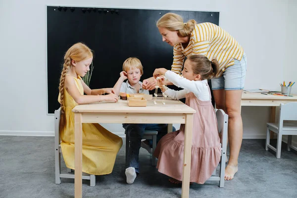 Турботливий вчитель допомагає дітям будувати 3d форми з пластиліну та зубочисток — стокове фото