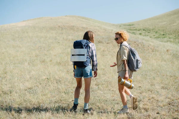 Parlare Amiche Che Camminano Colline Erbose Piedi Discutendo Qualcosa Sono — Foto Stock