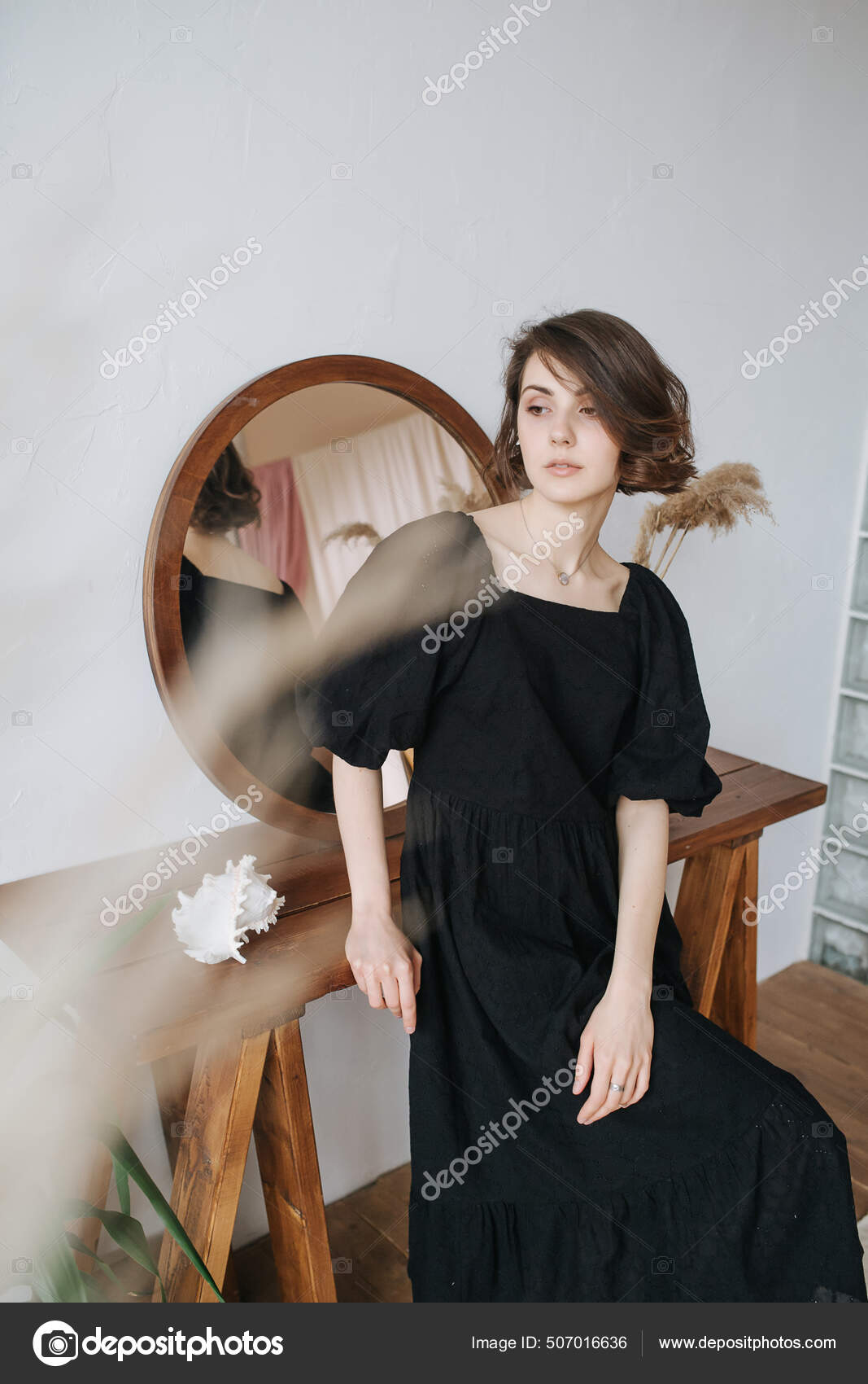 Uma mulher com cabelo curto e um vestido preto com um logo preto