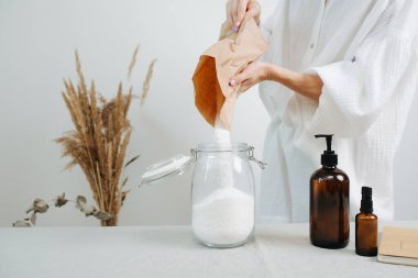 Bir kadın kimyagerin masadaki çevre dostu kozmetik ürünleri için bir karışım hazırladığına dair kafa resmi yok. Kavanoza beyaz toz dök..