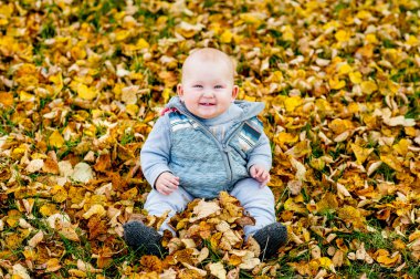 Küçük kızlar oturup üzerinde sonbahar yaprakları