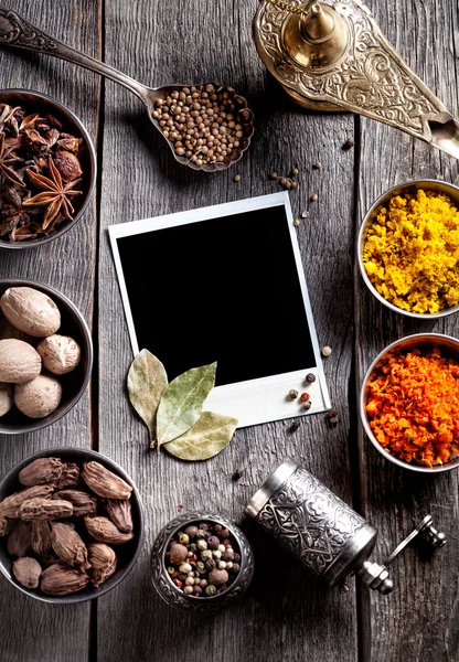 Specerijen en lege foto aan de tafel — Stockfoto