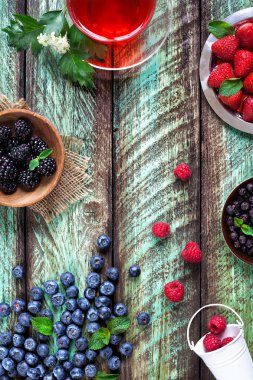 Bitkisel çay ve yeşil rustik masada çilek