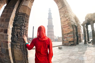 Woman looking at Qutub Minar clipart