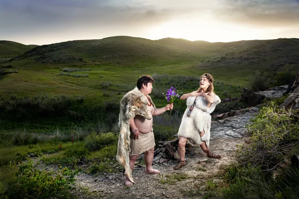 Casal de homem das cavernas apaixonado em montanhas — Fotografia de Stock