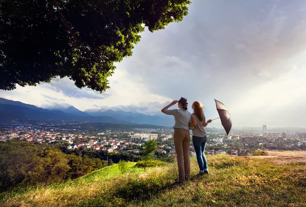 Amigos mirando al paisaje urbano en las montañas —  Fotos de Stock