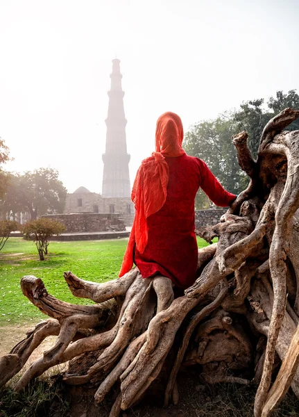 Mujer en vestido rojo mirando a Qutub Minar — Foto de Stock
