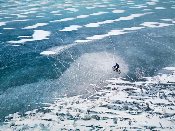 Top View Drone Záběr Člověka Kole Zamrzlém Jezeře Texturou Ledu — Stock fotografie