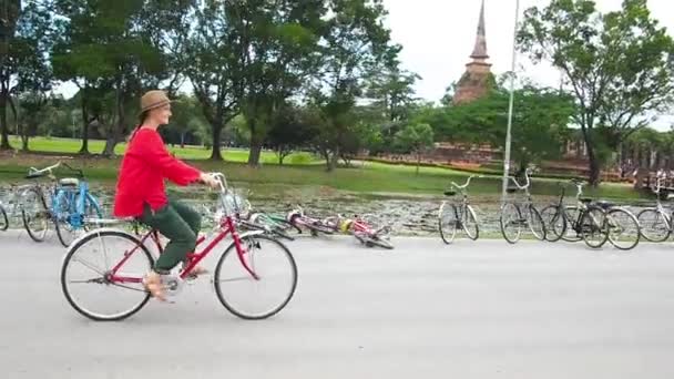 Woman ride bicycle near temple in Thailand — Stock Video