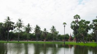 Tayland 'da tapınak yakınlarında bisiklet süren bir kadın.