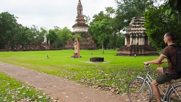 Homme vélo près du temple en Thaïlande — Video