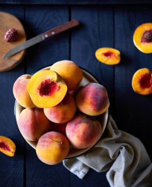 Köy evindeki mutfaktaki ahşap masada taze sulu şeftaliler.