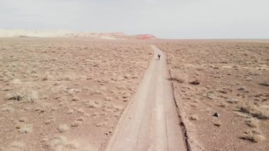 Kazakistan 'daki kanyon çöl dağlarında bisiklet sürerken insansız hava aracı görüntüleri.