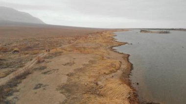 Kazakistan 'da nehrin yakınındaki çölde bisiklet sürerken çekilen robot resmi.