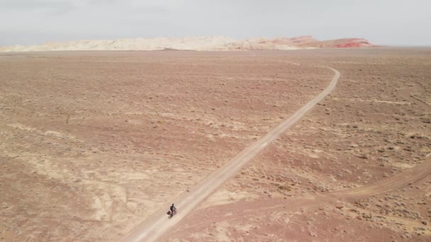 Drone shot van fietstocht in canyon woestijn bergen in Kazachstan — Stockvideo