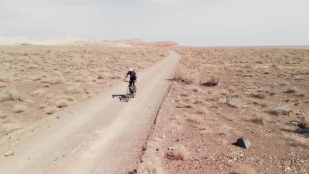 Drone tiro de passeio de bicicleta nas montanhas do deserto de cânion no Cazaquistão — Vídeo de Stock