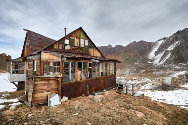 Almaty, Kazakistan 'da karlı dağ zirveleri olan vadide eski bir kır evi.