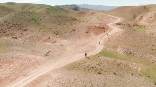 Drone shot groupe de balade cycliste dans les montagnes du Kazakhstan — Video