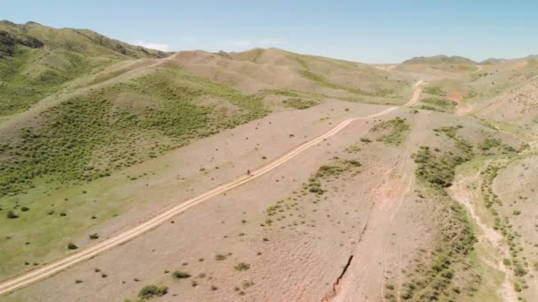 Drone tiro de passeio de bicicleta nas montanhas do Cazaquistão — Vídeo de Stock