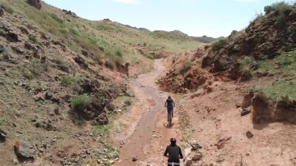 Strzał drona z jazdy rowerzystą w pustynnym kanionie — Wideo stockowe