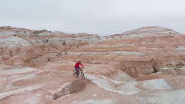 Drone tiro de passeio de bicicleta nas montanhas do deserto de cânion no Cazaquistão — Vídeo de Stock