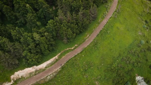 Homem passeio de bicicleta na estrada da montanha tiro aéreo — Vídeo de Stock