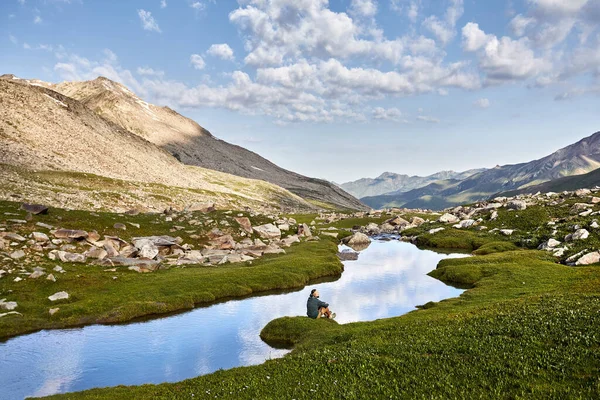 Man Zittend Rustend Buurt Van Heldere Bergrivier Met Reflectie Blauwe — Stockfoto