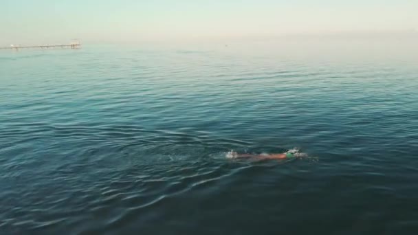 Aerial view of young woman swimming in the transparent turquoise sea water — Stock Video