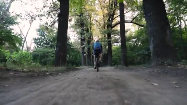 Велосипедист едет в городской парк на велосипеде — стоковое видео
