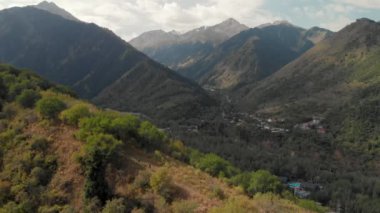 Kazakistan 'daki dağlarda, ormanda köpekle birlikte uçan kadın görüntüsü.