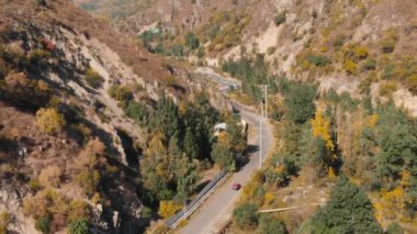 Sonbahar dağ ormanlarında kırmızı arabalı hava manzaralı yol