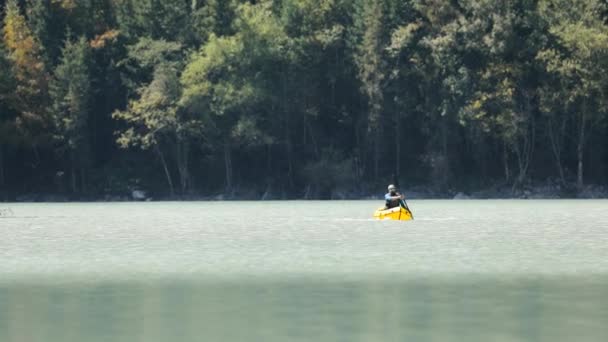 Människan paddlar på flotte båt i fjällsjön — Stockvideo