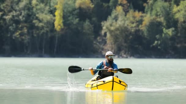 Människan paddlar på flotte båt i fjällsjön — Stockvideo