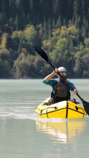 Человек катается на лодке в горном озере — стоковое видео